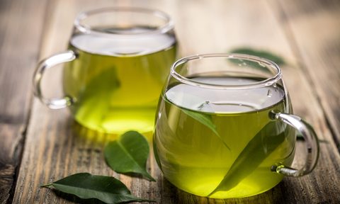 Fresh green tea with tea leaves in the water