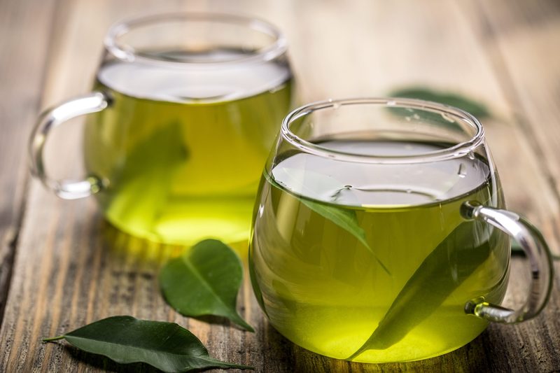 Fresh green tea with tea leaves in the water
