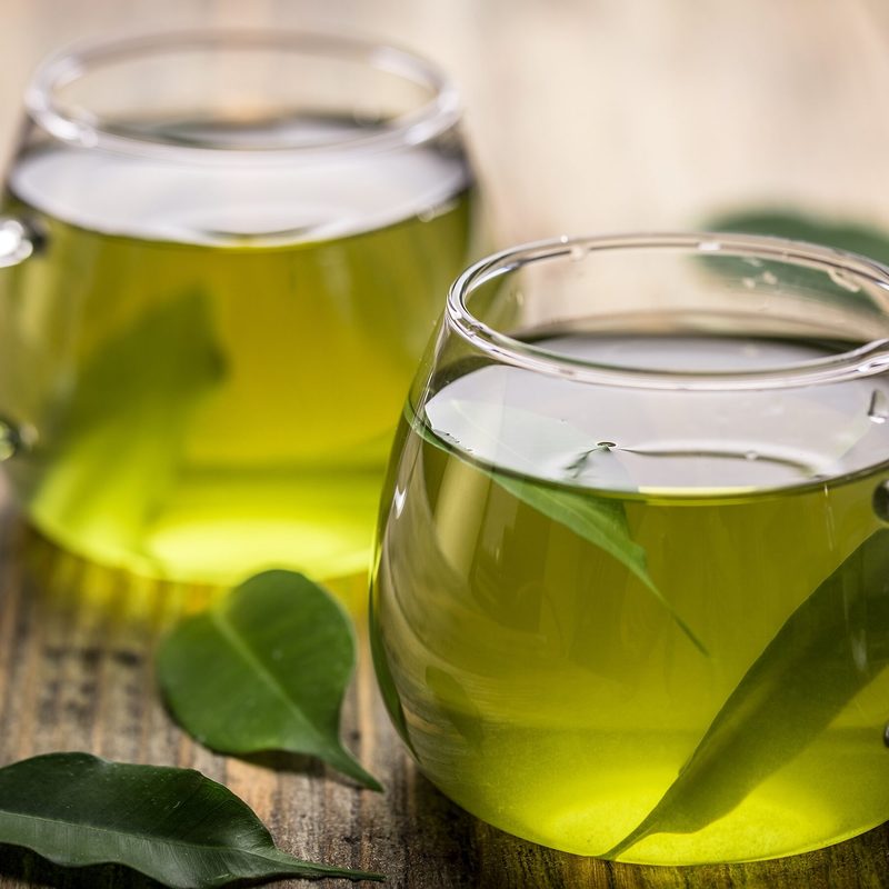Fresh green tea with tea leaves in the water