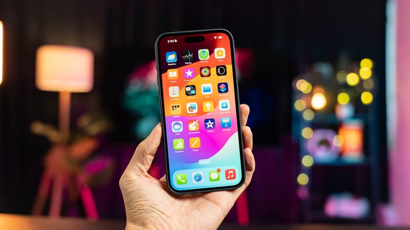 A hand holding up an iPhone with the screen showing