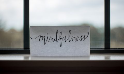 Mindfulness word written on white paper by window