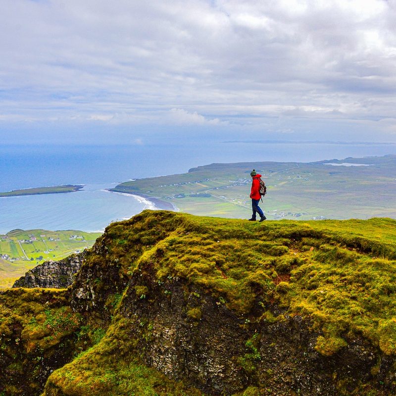 Man in the distance hiking seaside mountains