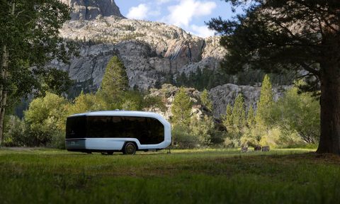 Pebble electric RV travel trailer in a grassy field in the mountains.