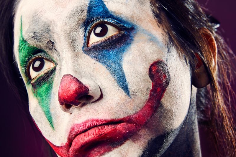 Close-up image of man wearing clown makeup