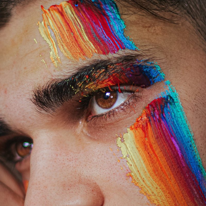 Close-up of man wearing rainbow face paint
