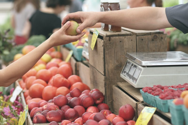 one person handing a piece of fruit to another