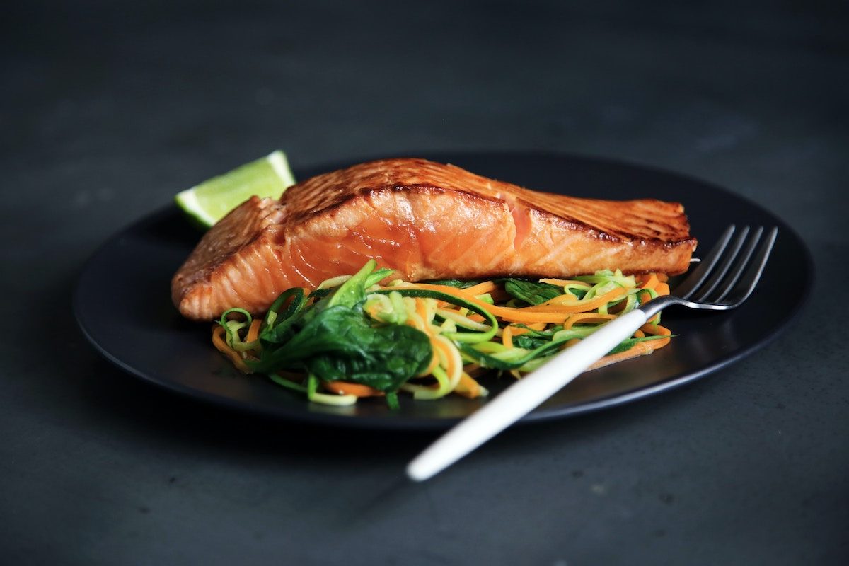 a plate of salmon on a dark gray table