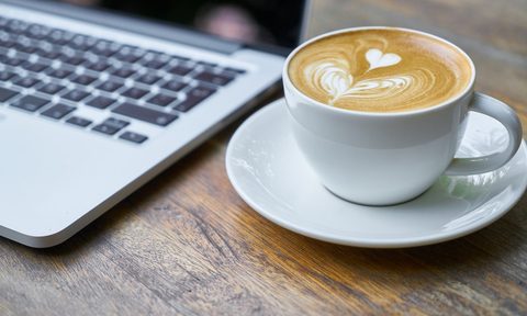 Pumpkin coffee by a computer