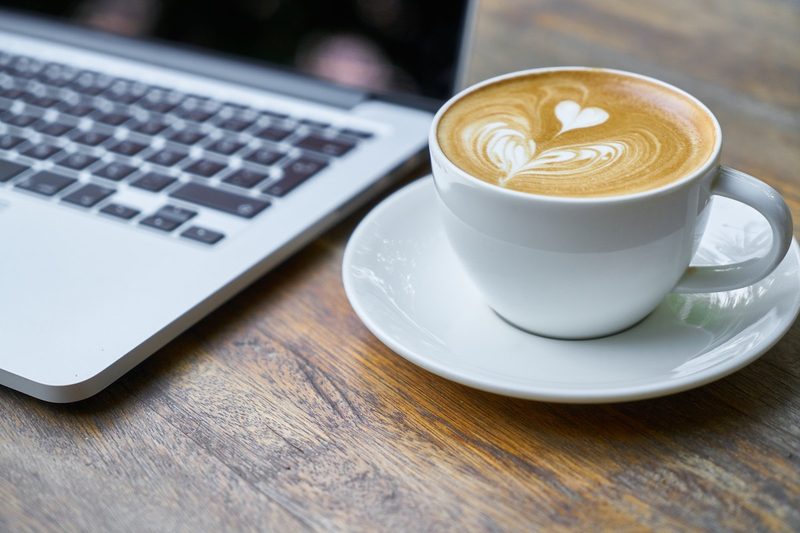 Pumpkin coffee by a computer