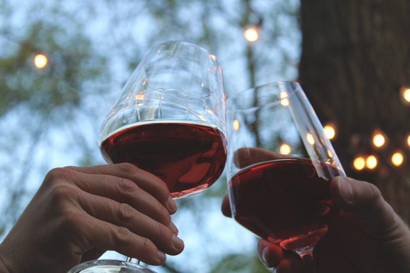 Hands toasting with red wine