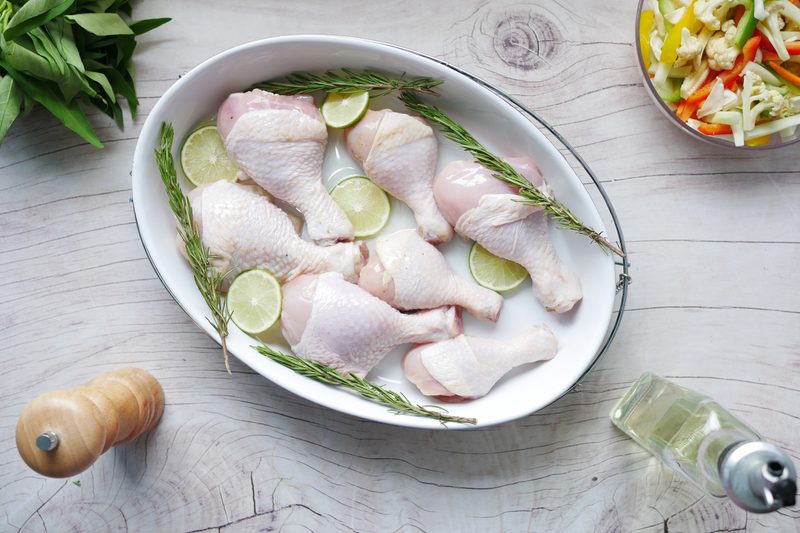 Raw chicken legs in pan