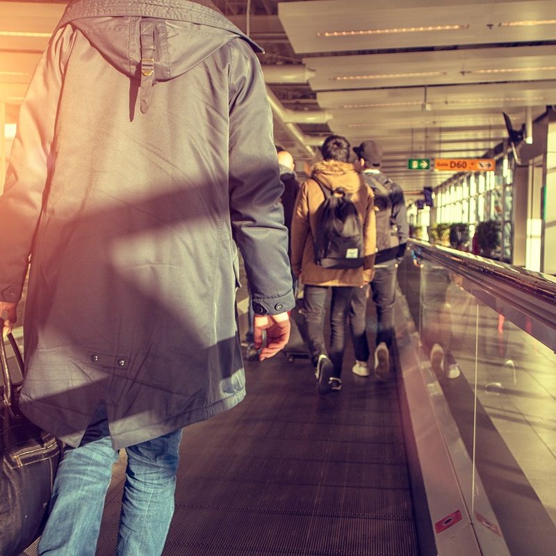 The back of a passenger on a moving sidewalk in an airport