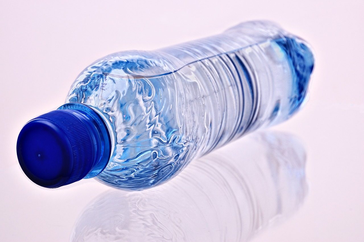 plastic water bottle with a blue lid laying on its side