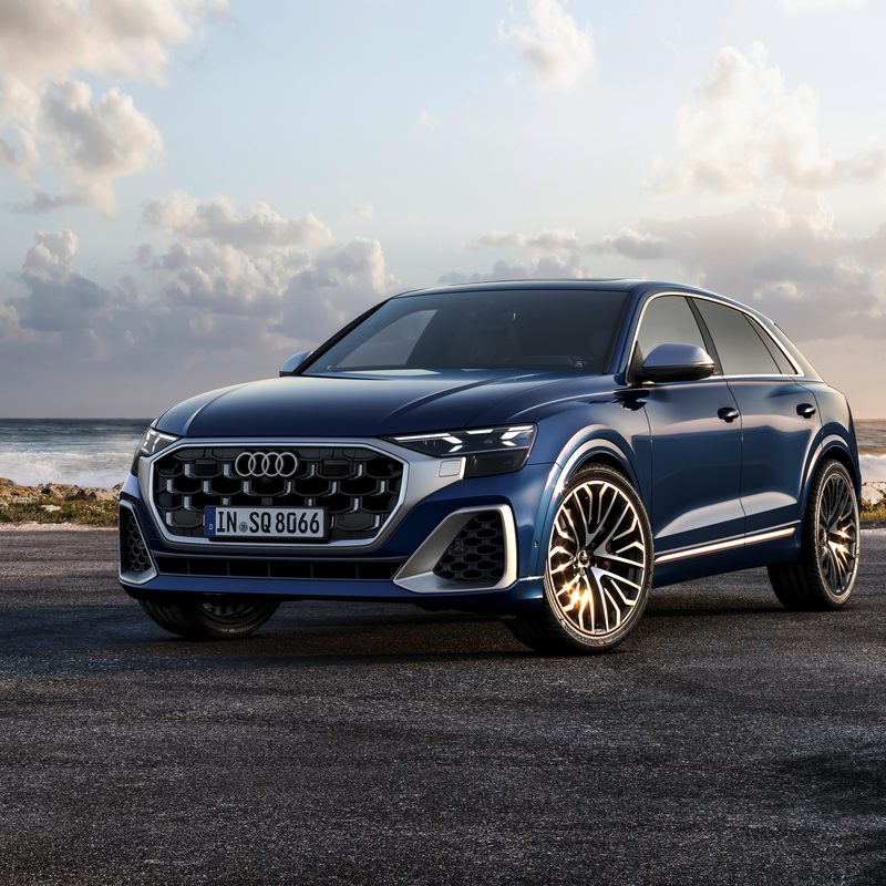 2024 Audi S Q8 in Waitomo Blue left front three-quarter view on pavement near the ocean shore - European Model Shown..