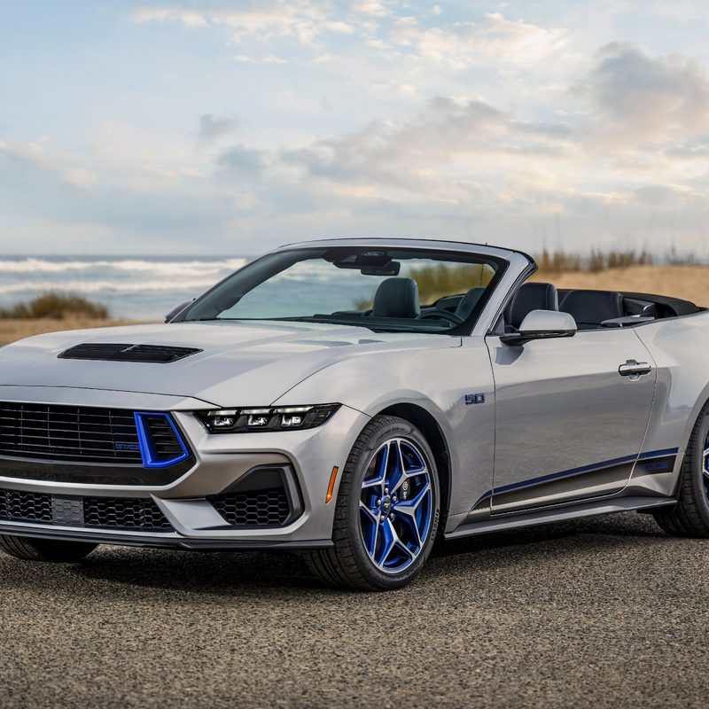 2024 Ford Mustang GT California Special convertible parked by the beach with the top down three-quarter view from the left front