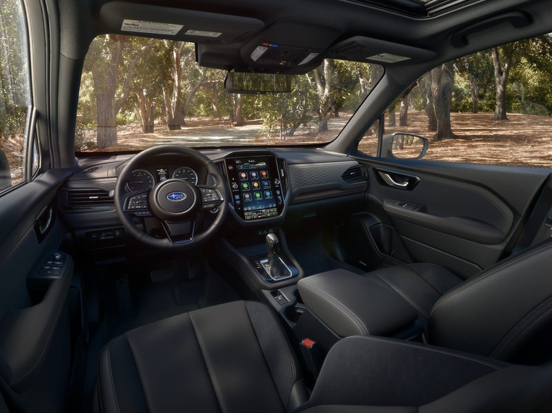 2025 Subaru Forester interior view with camera looking down from in back of the driver seat with large console display in the center.