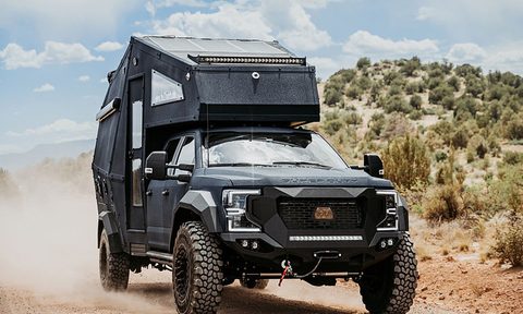 27North F550 Ascender overlander truck camper driving down a dirt road.