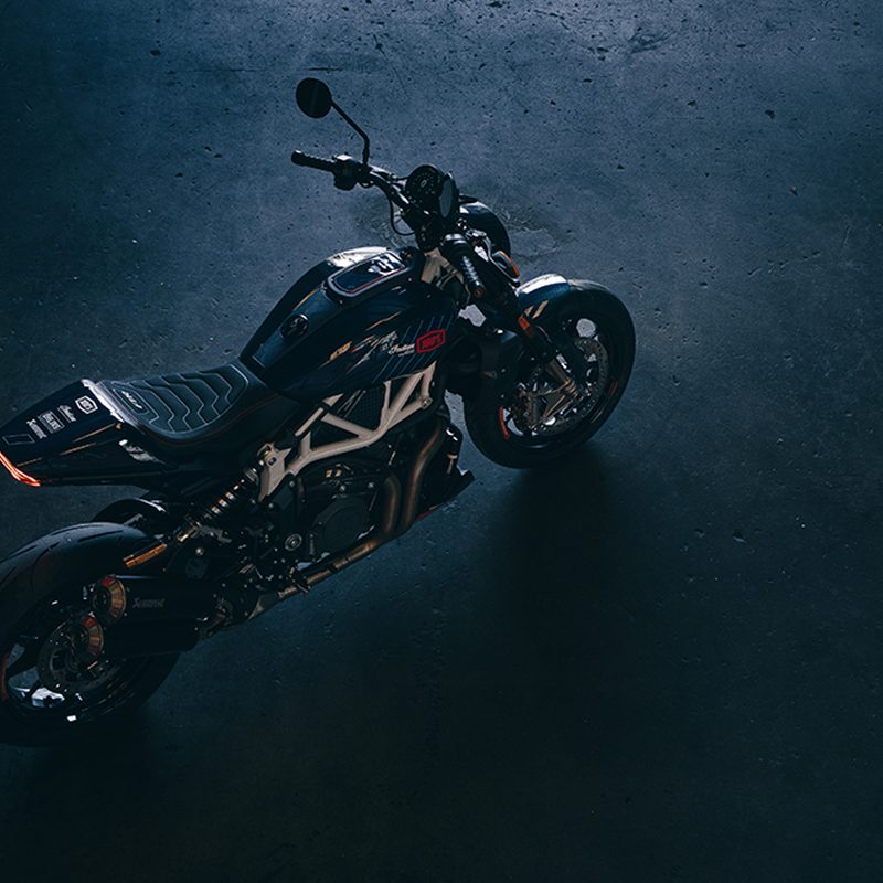 A view from above an Indian Motorcycle 2024 FTR x 100% R limited edition parked on a shiny black surface