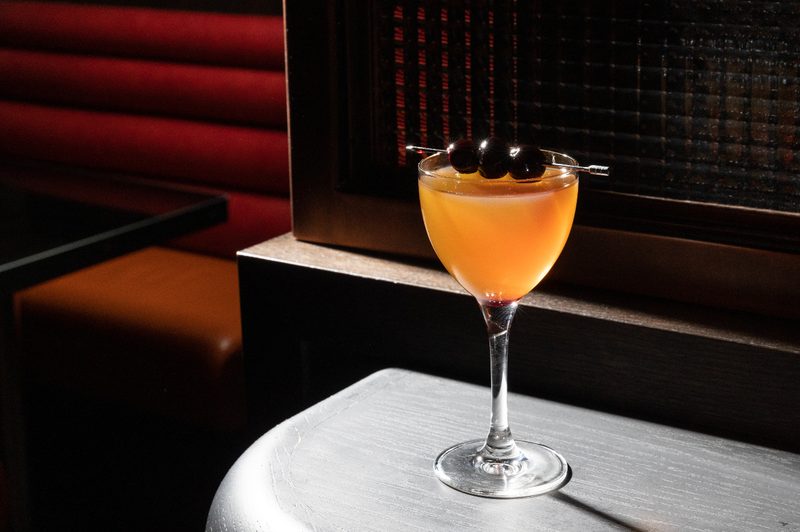 black Manhattan cocktail on table