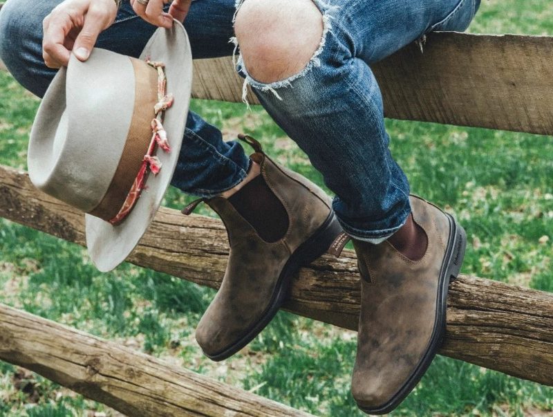Man wearing Blundstone Rustic on fence