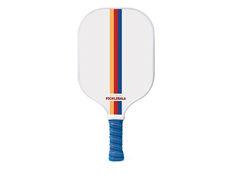 The yellow, red, and blue striped version of the Brooklyn Pickleball Co. pickleball paddle.