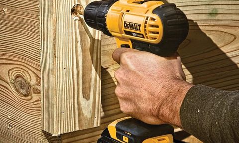 A DeWALT drill bearing into wood.