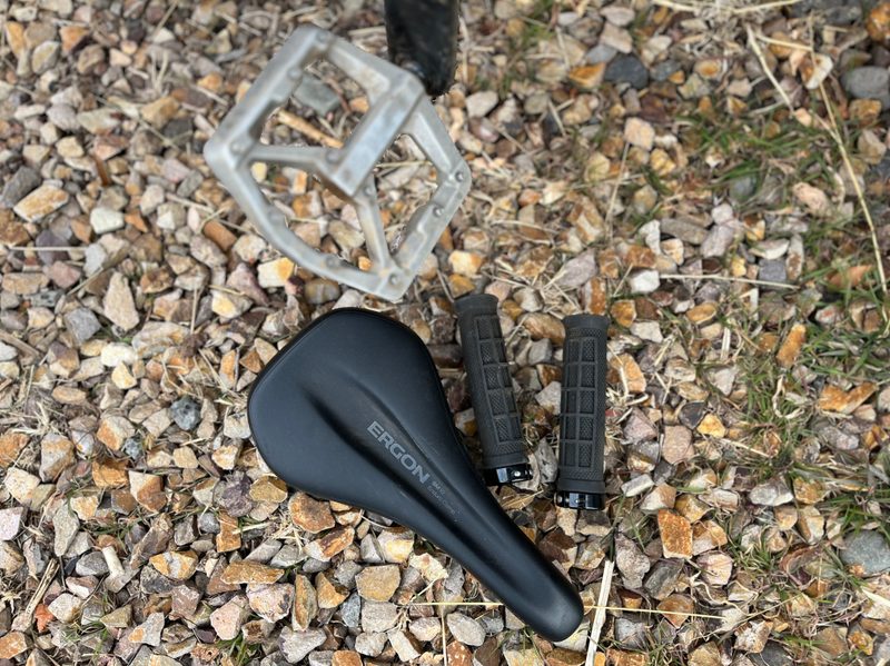 A mountain bike seat, pedals, and grips. These are mountain biking touchpoints, where your body physically comes into contact with your bike.