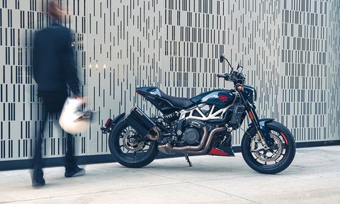 Motorcycle rider out of focus carrying helmet toward Indian Motorcycle 2024 FTR x 100% R limited edition
