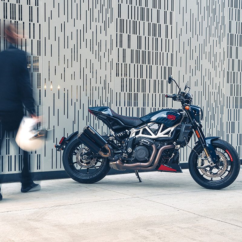 Motorcycle rider out of focus carrying helmet toward Indian Motorcycle 2024 FTR x 100% R limited edition