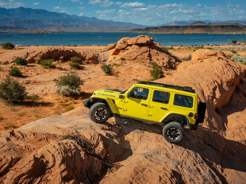 Yellow 2024 Jeep Wrangler Rubicon X4e rock climbing at a state park in Utah.
