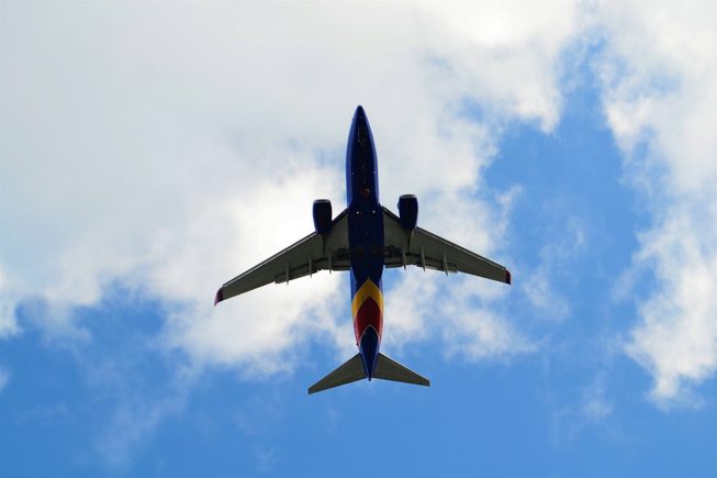 The view from the ground looking up at the underside of a Southwest Airlines plane in flight