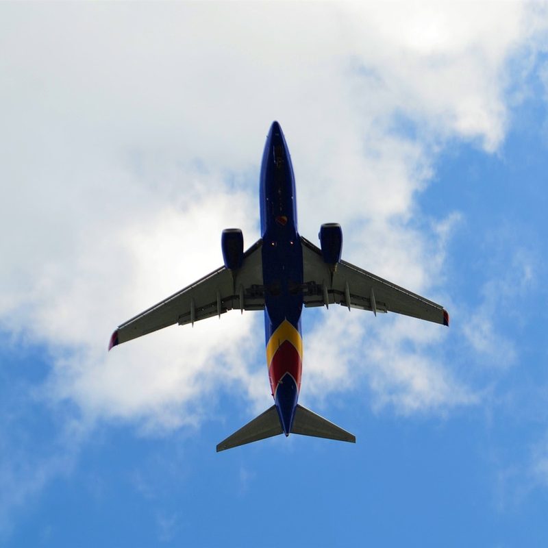 The view from the ground looking up at the underside of a Southwest Airlines plane in flight