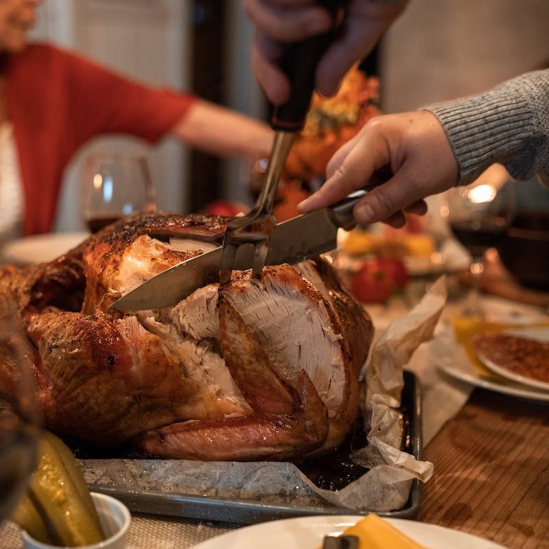 A person carving a turkey on Thanksgiving