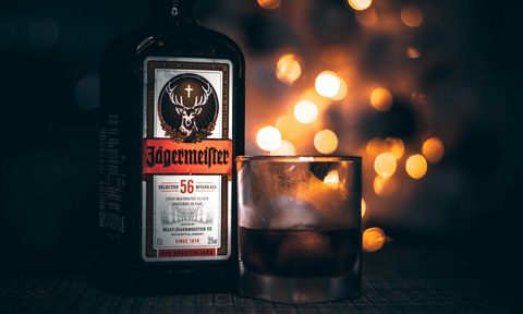 Jägermeister in a bottle next to a glass of it