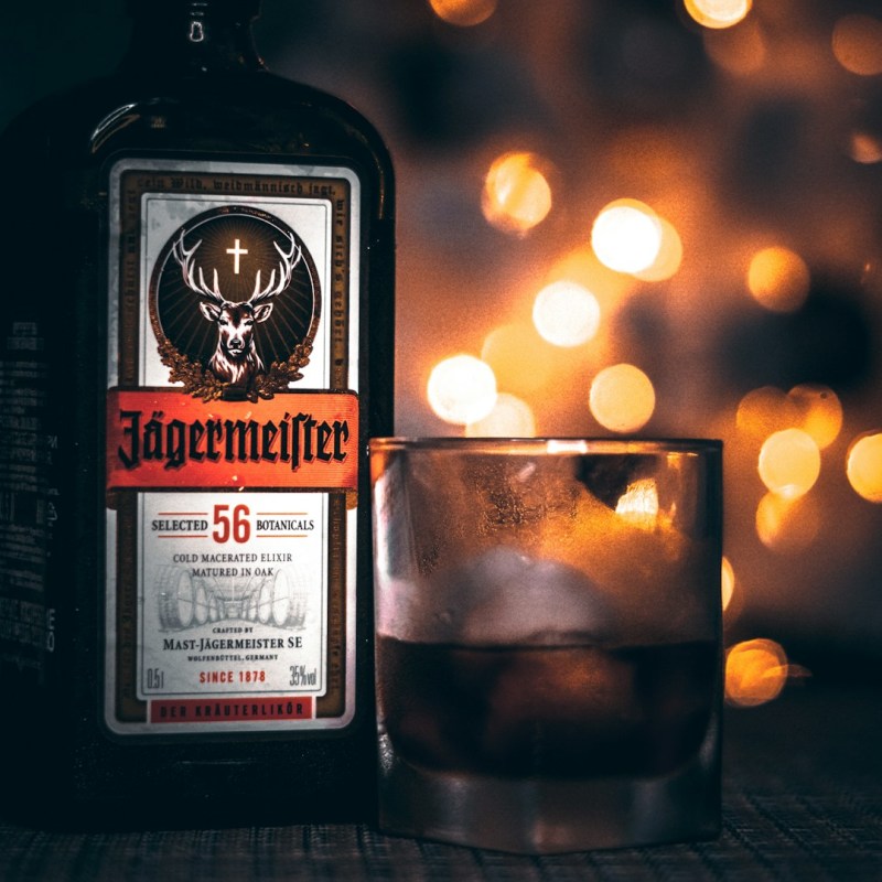 Jägermeister in a bottle next to a glass of it