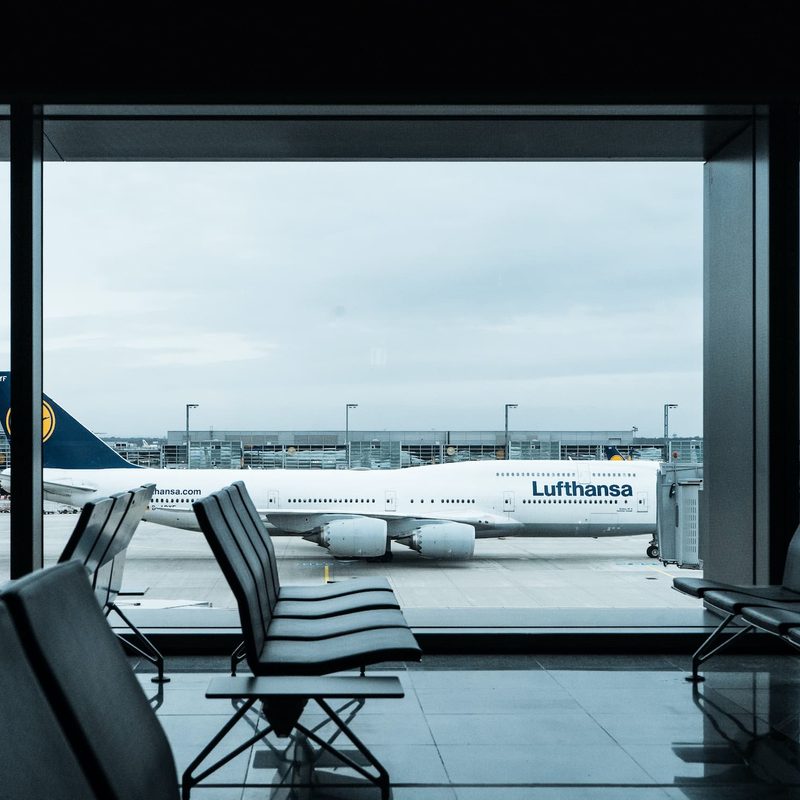 Empty seats in airport with a plane outside in background