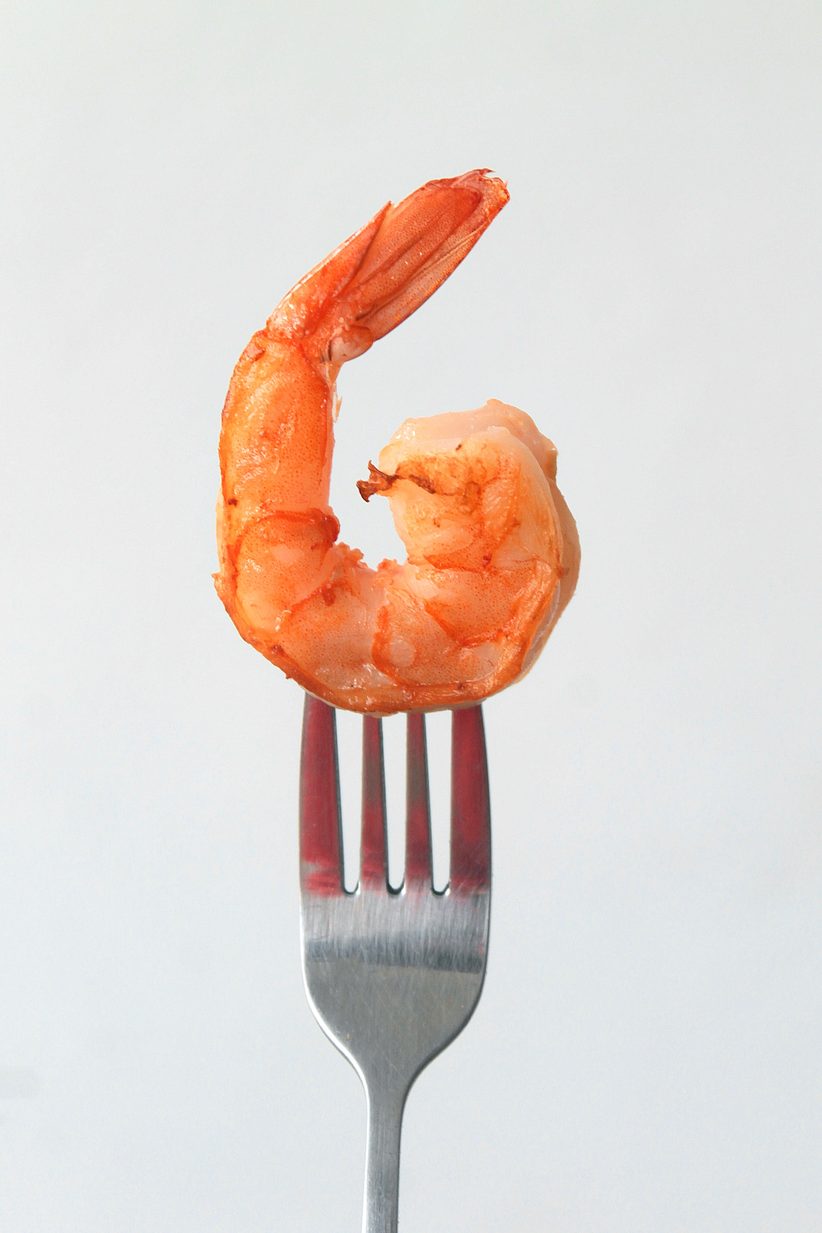 shrimp on a silver fork and grey background