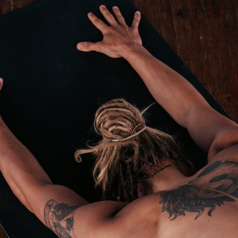 Man stretches out on yoga mat child's pose