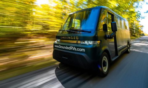 Blurred view of the Grounded RVs G2 electric RV camper van driving down a country road.