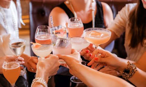 Crowd of people toasting with cocktails