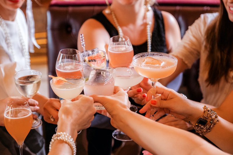 Crowd of people toasting with cocktails
