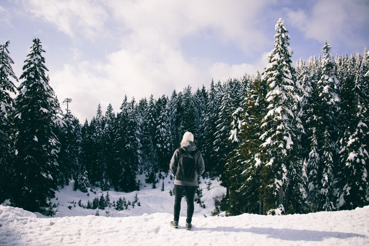 Solo hiker taking in the view along trail in winter