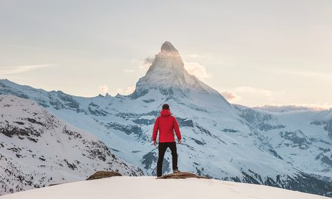Man standing in front of snowy mountains