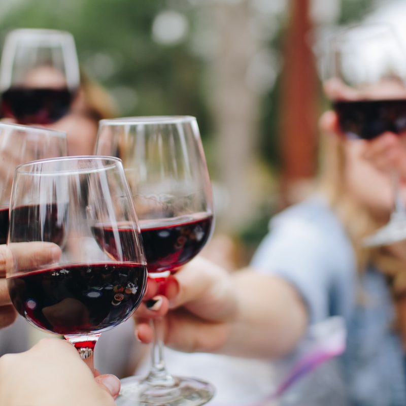 Hands toasting with red wine