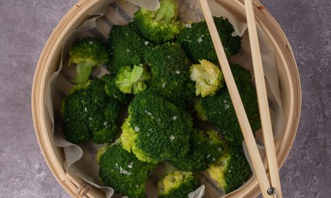 Broccoli in a beige ceramic bowl with chopsticks