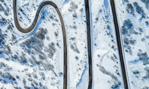 A winding road through the snowy rocky mountains