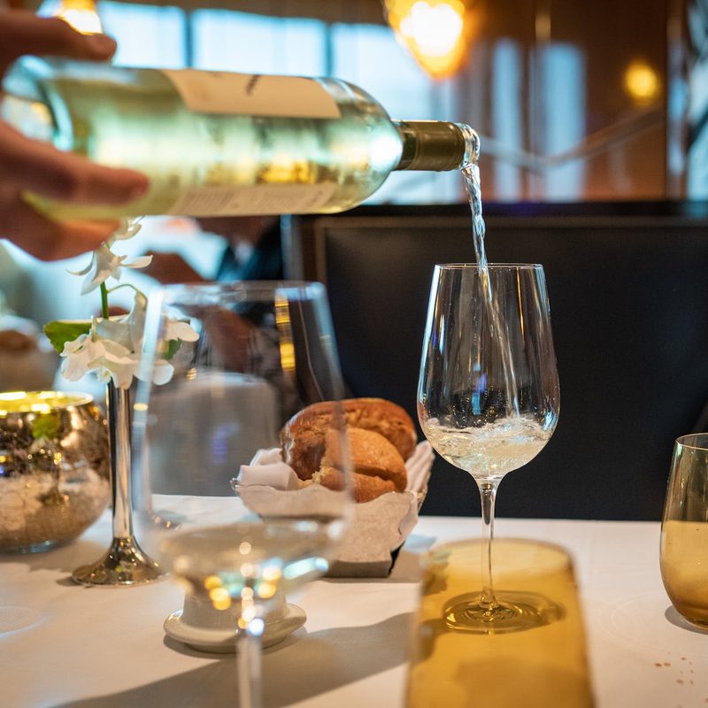 White wine being poured at table