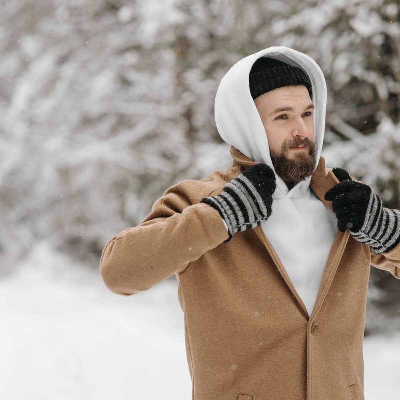 Man standing outside in snow wearing gloves