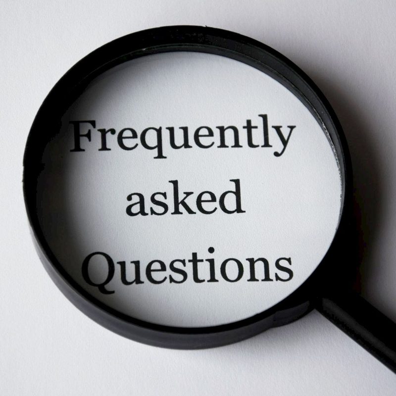 Frequently asked questions FAQs on paper looking through black magnifying glass