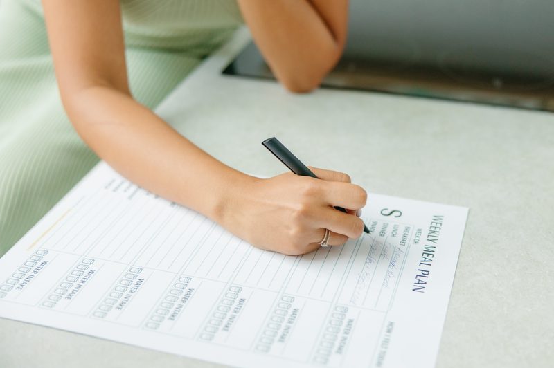 Person holding a pen and filling in a worksheet